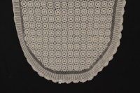 Lote 209 - TOALHA EM RENDA DE CROCHET - Toalha oval em renda de crochet manual em linha bege, com desenho de rosetas e remate recortado. Etiqueta com pvp de € 135. Dim: 170x260 cm. Nota: sem uso, com etiqueta A Bilha