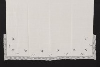 Lote 303 - LENÇOL DE LINHO COM BORDADOS E RENDAS - Lençol em tecido branco bordado à mão com desenho floral, com entremeio de renda branca. Dim: 230x90 cm. Nota: tecido com manchas de estar guardado