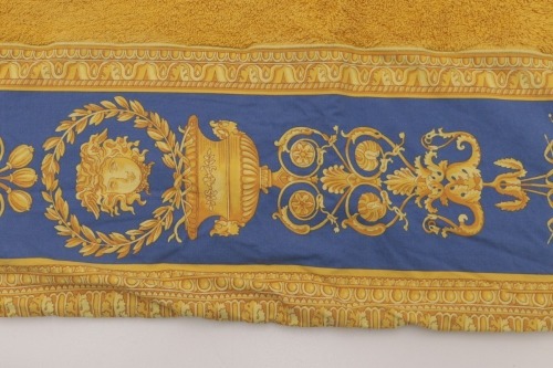 Lote 30 - VERSACE HOME, TOALHA DE BANHO - Made in Italy, toalha de banho em tecido turco amarelo, barra azul e amarela de padrão "Baroque". Modelo com pvp de € 250. Dim: 96x150 cm