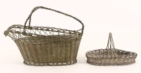 Lote 135 - CONJUNTO EM METAL PRATEADO - Composto de cesto para garrafa e cesto oval em arame de metal prateado entrançado. Dim: 18x24x11 cm e 10x15x8 cm respectivamente