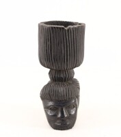 Lote 169 - ARTE TRÍBAL AFRICANA, CINZEIRO - Em pau preto entalhado com 2 cabeças de africanos. Dim: 18,5 cm