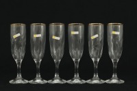 Lote 240 - CRISTAL MODE, FLUTES DE PÉ ALTO - Conjunto de 6 flutes em cristal, bordo decorado com friso dourado. Dim: 20 cm. Nota: sinais de uso