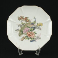 Lote 39 - PRATO DECORATIVO EM PORCELANA CHINESA - Decoração policromada com flores e pavão, bordo recortado com ornamentos dourados, marcado na base, Fabricado em Macau. Dim: 22 cm