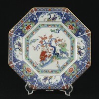 Lote 111 - PRATO EM PORCELANA JAPONESA - Prato de formato oitavado com decoração policromada com flores e figuras orientais, marcado na base. Dim: 26x26 cm